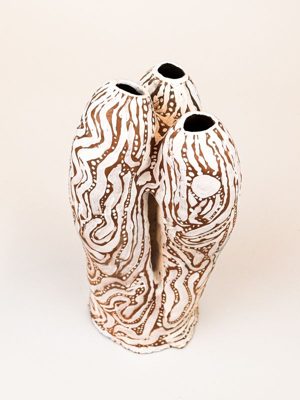 photograph of earthen ceramic sculpture, hand painted with patterns, side view, thumbnail